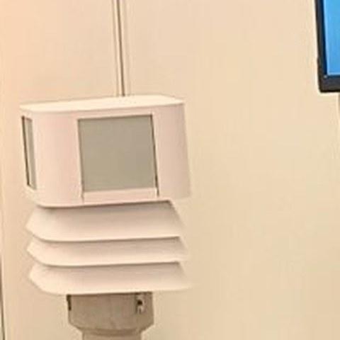 A MoriShield sensor head mounted above a white louvered radiation shield on a post
